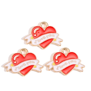 Macro shot of red enamel heart charms with white ribbons and I love you engraving