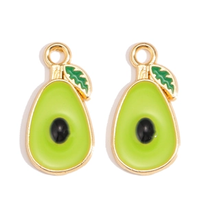 Macro-opname van twee avocado emaille bedeltjes met gouden randen en groene bladeren