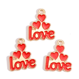 Close-up of red enamel heart and love letter charms for DIY jewelry making