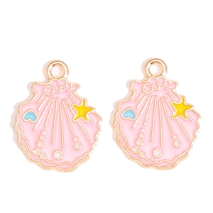 Détail des breloques coquillages en émail rose et or pour création de bijoux DIY