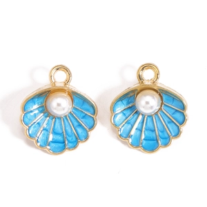 Détail de breloques coquillages en émail bleu ciel avec perle blanche et cadre doré