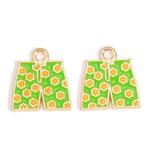 Detailed view of green enamel shorts charms with yellow flower patterns for DIY jewelry