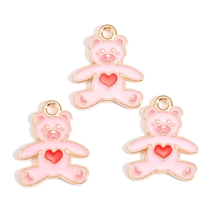 Detail of pink enamel bear charms with red heart and gold metal frame for DIY jewelry