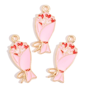 Detailed view of pink floral alloy charms with red heart accents and golden bow for DIY jewelry