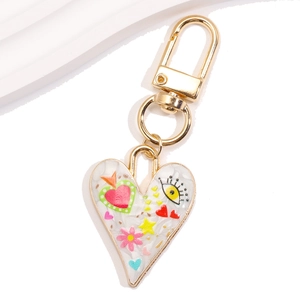 Macro shot of heart shaped metal keychain with evil eye patterns and gold finish detail