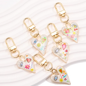 Five-piece heart-shaped evil eye keychains with pop art floral prints and gold edges