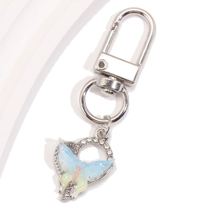 Vue macro d'un porte-clés papillon avec ailes dégradées bleues et strass