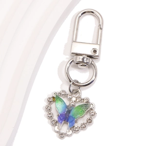 Détail d'un porte-clés en forme de cœur avec papillon dégradé et cristaux brillants