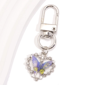 Détail d'un porte-clés en forme de cœur avec papillon coloré et strass brillants