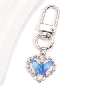 Détail du pendentif en cœur avec papillon dégradé bleu sur un porte-clés argenté brillant