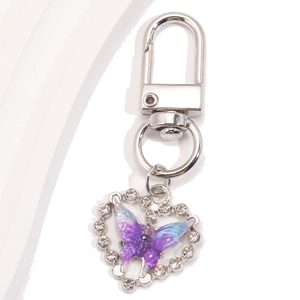 Détail d'un porte-clés cœur avec papillon violet et strass sur fermoir mousqueton argent