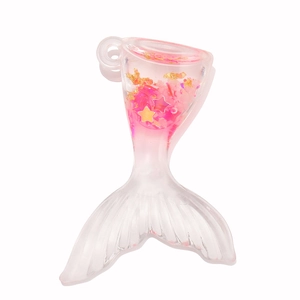 Détail de pendentif sirène en résine avec liquide rose et paillettes dorées brillantes