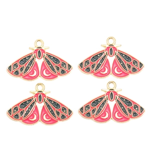 Détail de quatre breloques papillon en alliage émaillé rouge avec motifs lune et étoiles