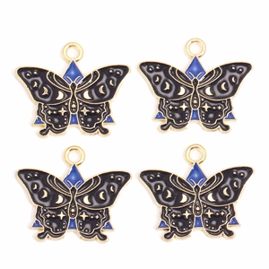Lot de quatre pendentifs papillon en émail noir avec motifs célestes étoilés dorés