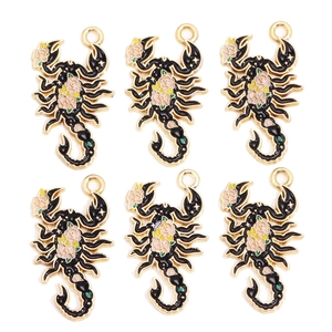 Détail de six pendentifs scorpion en alliage avec émail noir et motifs floraux