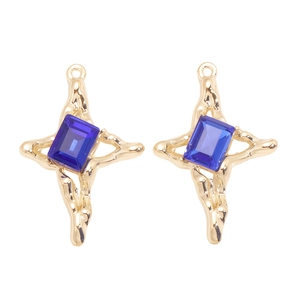 Détails macro de pendentifs croix dorés Y2K avec texture lave et cristaux bleus