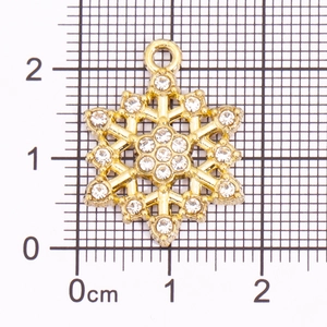Goldener Schneeflocken-Anhänger mit Strasssteinen auf Millimeterpapier für DIY-Schmuck