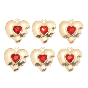 Détail de six breloques cœurs dorés avec résine rouge pour la création de bijoux DIY