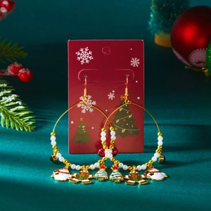 Nahaufnahme goldener Weihnachts-Ohrringe mit Schneemann-, Lebkuchenmann- und Emaille-Anhängern
