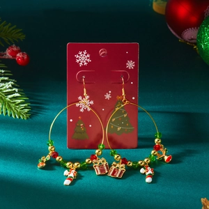 Detailaufnahme von Weihnachts-Creolen mit Zuckerstangen und Geschenk-Anhängern auf Dekor