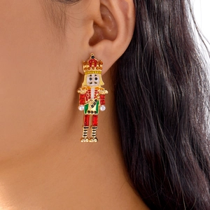 Détail de boucles d'oreilles Casse-noisette avec émail et perles portées par un mannequin