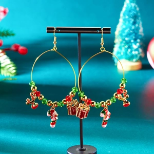 Detailaufnahme von Weihnachts-Ohrringen mit Glöckchen und Zuckerstangen am Schmuckständer