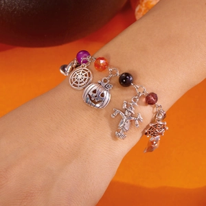 Bracciale di Halloween con ciondoli a zucca, fantasma e ragnatela in primo piano