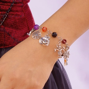 Dettaglio del bracciale di Halloween con ciondoli zucca, ragnatela e spaventapasseri