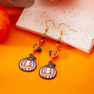 Dettaglio di orecchini di Halloween con perle a zucca e ciondolo a cappello da mago