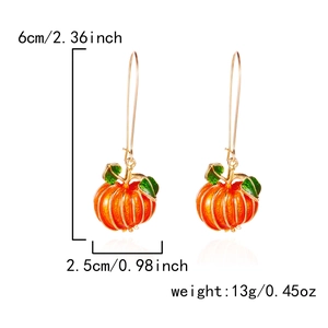 Dettaglio di orecchini a zucca arancione con dimensioni 6cm x 2,5cm e accenti di foglie