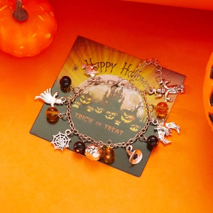 Bracciale a tema Halloween con ciondoli a fantasma e zucca su carta festiva