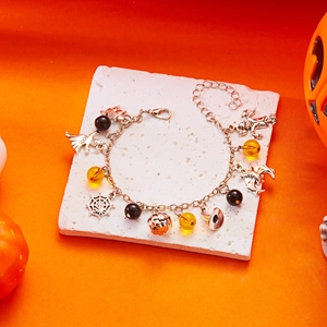 Bracciale di Halloween con ciondoli a forma di fantasma zucca e cappello da strega su sfondo arancione