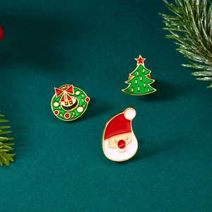 Detail der Weihnachts-Emaille-Broschen mit Weihnachtsmann, Baum und Kranz auf Tannenzweigen