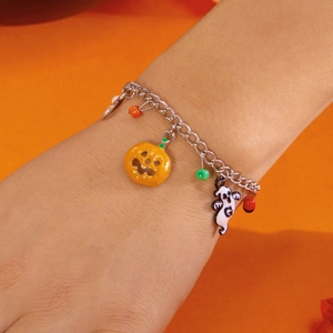 Dettaglio del bracciale di Halloween con ciondoli a fantasma e zucca sul polso