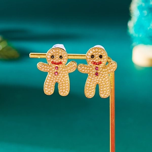 Détail de boucles d'oreilles bonhomme de pain d'épices avec perles et cristaux rouges