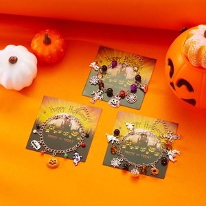 Braccialetti di Halloween con ciondoli a fantasma zucca e ragnatela su carte festive