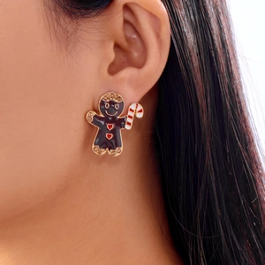 Gros plan d'une boucle d'oreille bonhomme de pain d'épices avec strass sur l'oreille