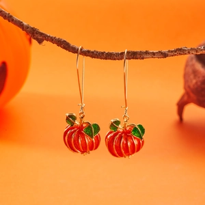 Dettaglio di orecchini a forma di zucca smaltata con ganci dorati per Halloween