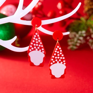 Close-up van acryl kerstoorbellen met kerstman-kabouterontwerp op een wit rendierstandaard