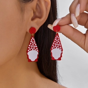 Detail van rood en wit gestipte kabouter acryl oorbellen op model voor kerstmis