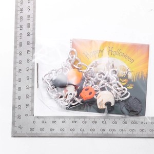 Detail of Halloween layered necklace with ghost and skull charms on a scale measuring map