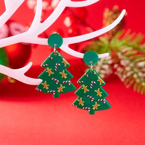 Detailweergave van groene kerstboom oorbellen van acryl met peperkoekman patroon