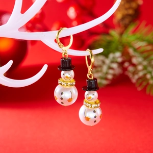 Macro view of Christmas snowman pearl earrings with rhinestones and black holiday hat