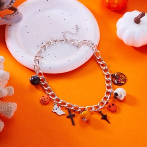 Macro detail of Halloween charm bracelet with pumpkin, ghost and skull pendants