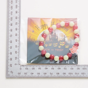 Luminous Halloween pumpkin ghost beaded bracelet with size ruler on festive card