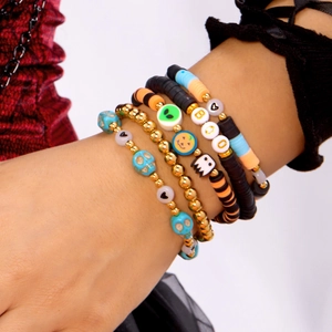 Detail of Halloween beaded bracelets with BOO letters and pumpkin charms on a model wrist