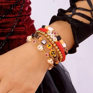 Close-up of stacked Halloween clay bead bracelets with skull, pumpkin and BOO charms