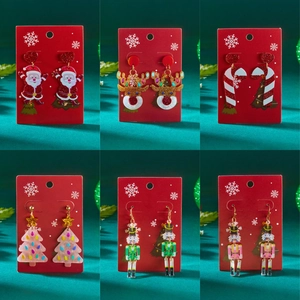 Set di orecchini natalizi in acrilico rosa con glitter e motivi festivi su sfondo verde