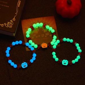 Luminous Halloween bracelets with pumpkin pendants glowing in neon green and blue colors