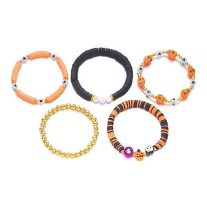 Close-up of Halloween stretch bracelets with orange pumpkin, skull, and BOO beads
